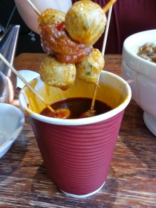 Squid balls and sausage balls on a stick, dipped in a spicy sauce. 